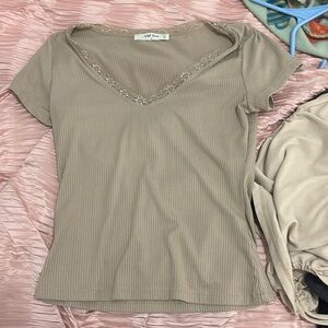 Tan color with a v neck lose shirt with lacing on the v neck